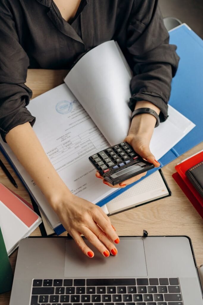 pexels-photo-8296981 Person Holding Black Calculator While Using Laptop